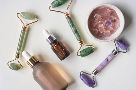 Crystal facial rollers made of jade, amethyst, and rose quartz for skincare and glowing skin