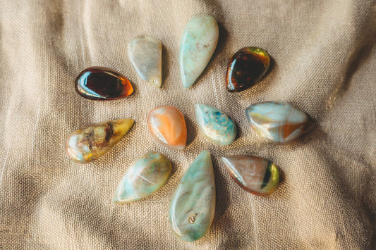 Collection of black, white, and fire opal stones displayed in natural light.