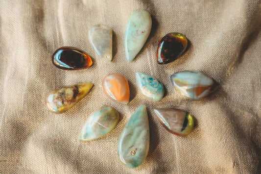 Collection of black, white, and fire opal stones displayed in natural light.
