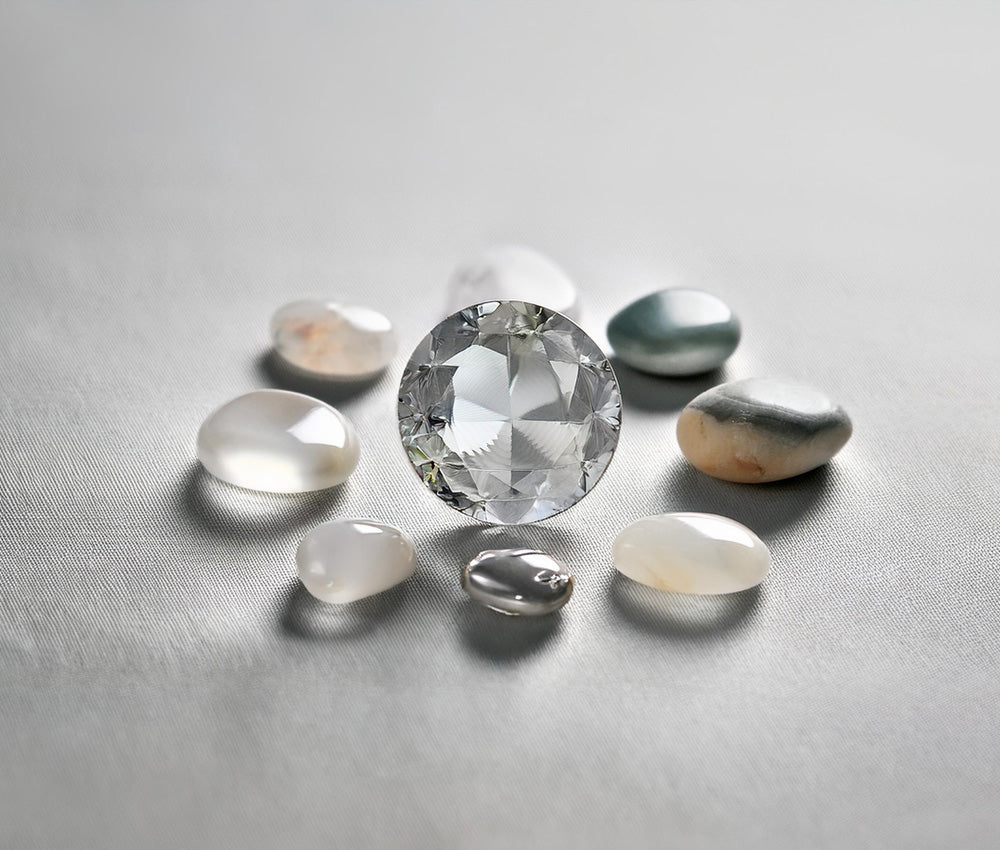 Polished diamond stones on a light gray background, emphasizing clarity and connection to the Crown Chakra.