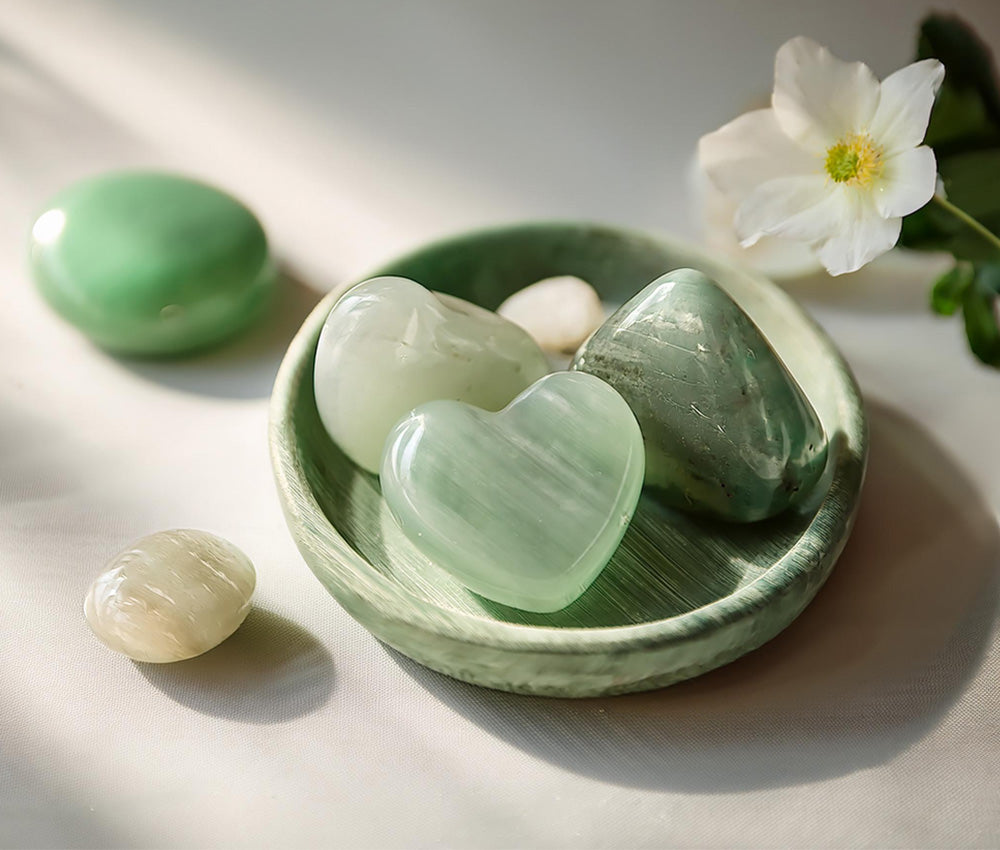 Jade stones on a light surface, highlighting their connection to the Heart Chakra and promoting love and emotional healing.