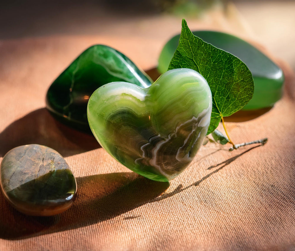 Moss agate stones on a neutral background, highlighting their connection to the Heart Chakra and promoting love and emotional healing.