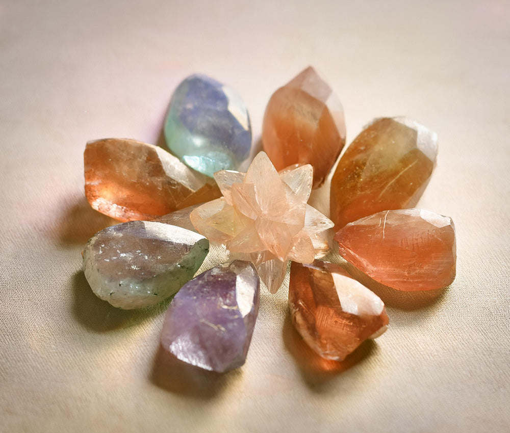 Topaz stones arranged by color, highlighting their connections to the Solar Plexus, Throat, and Heart Chakras for confidence, communication, and love.