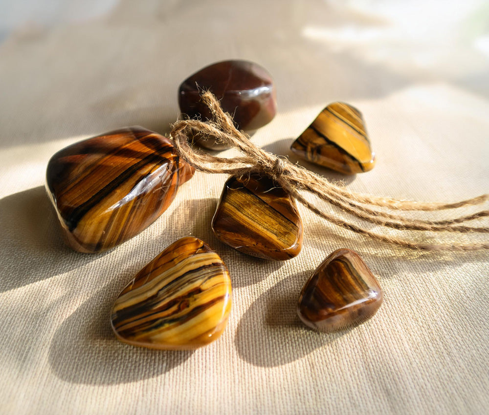 Tiger’s eye stones on a light background, highlighting their connection to the Solar Plexus and Root Chakras for confidence and grounding.