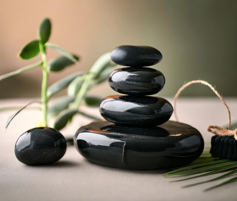 Obsidian stones on a neutral surface, highlighting their connection to the Root Chakra and grounding energy.