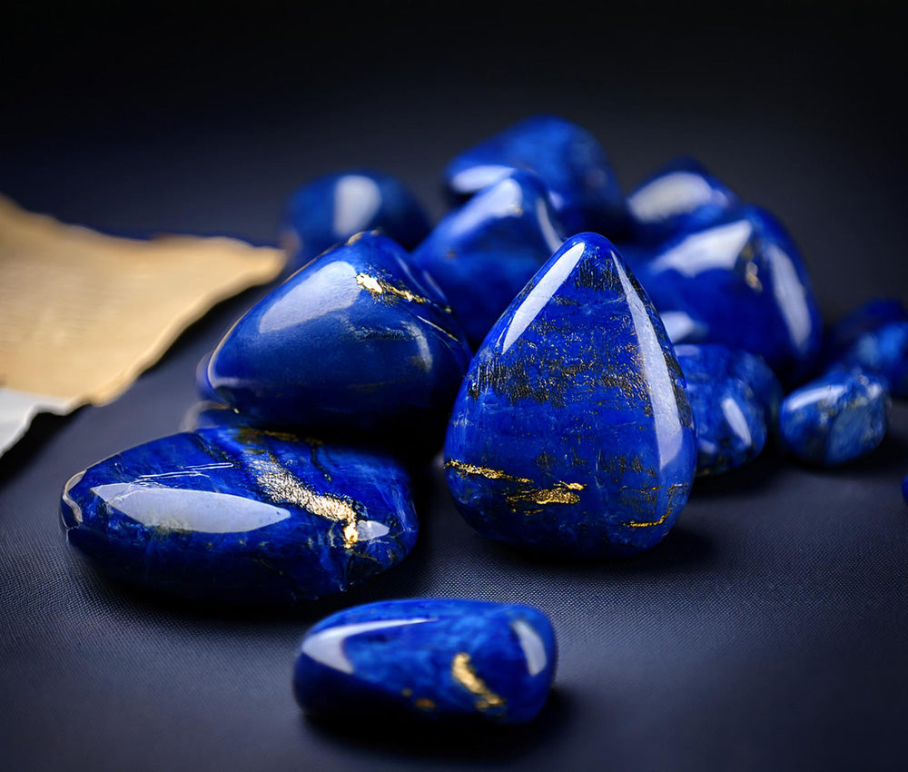 Lapis lazuli stones on a dark background, showcasing their vibrant color and gold speckles, symbolizing divine wisdom and spiritual enlightenment.