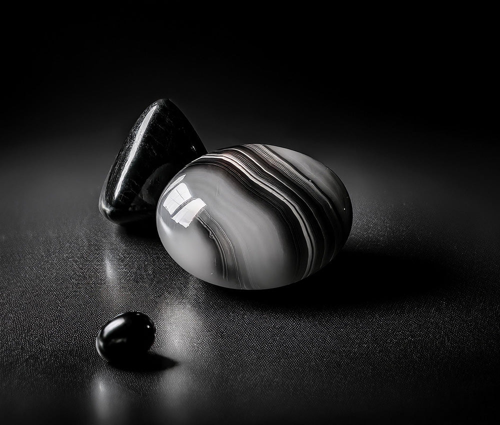 Polished onyx stones on a dark surface, symbolizing strength, protection, and historical use in ancient cultures.