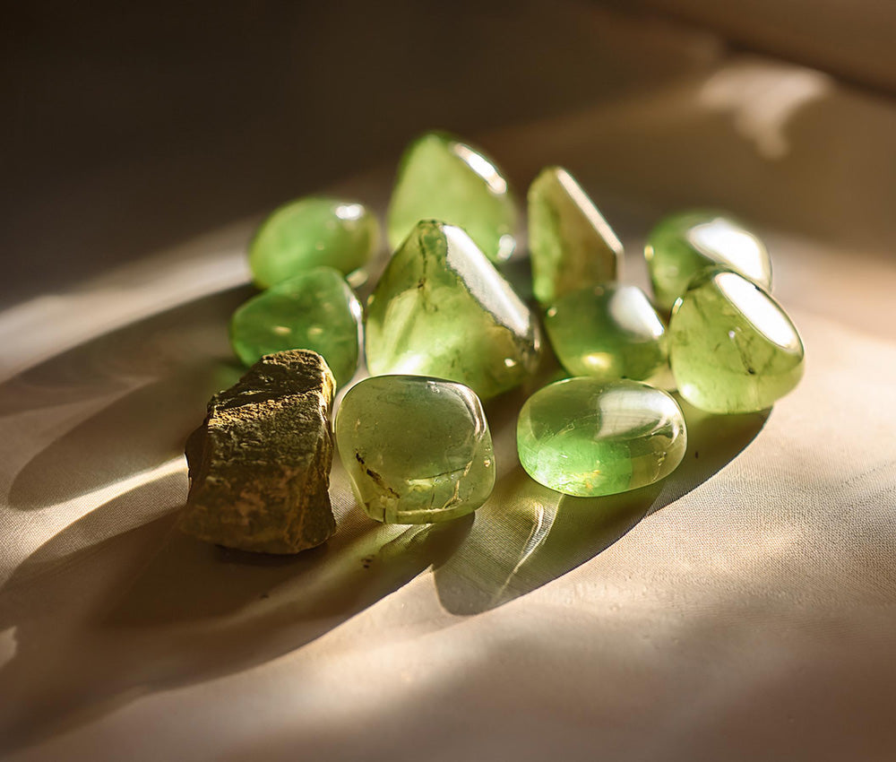 Peridot stones on a warm surface, symbolizing their historical significance as the "Gem of the Sun" and a stone of protection and renewal.