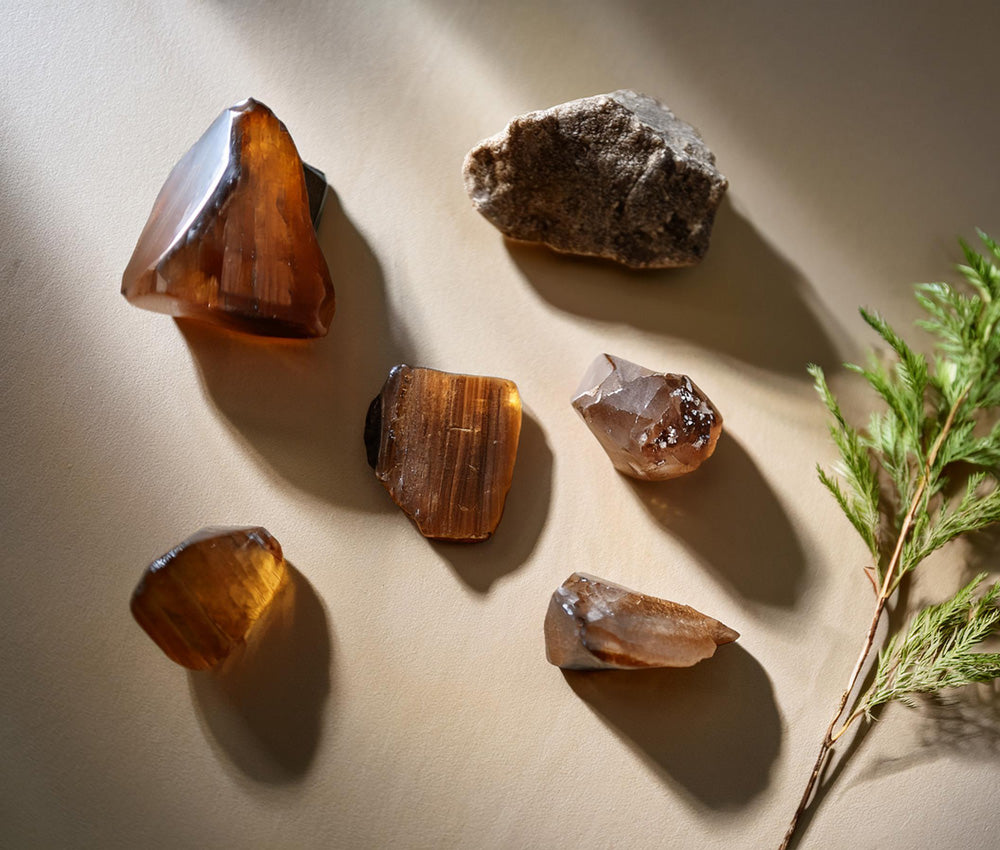 Smoky quartz stones on a neutral surface, highlighting their connection to the Root Chakra and promoting grounding and resilience.