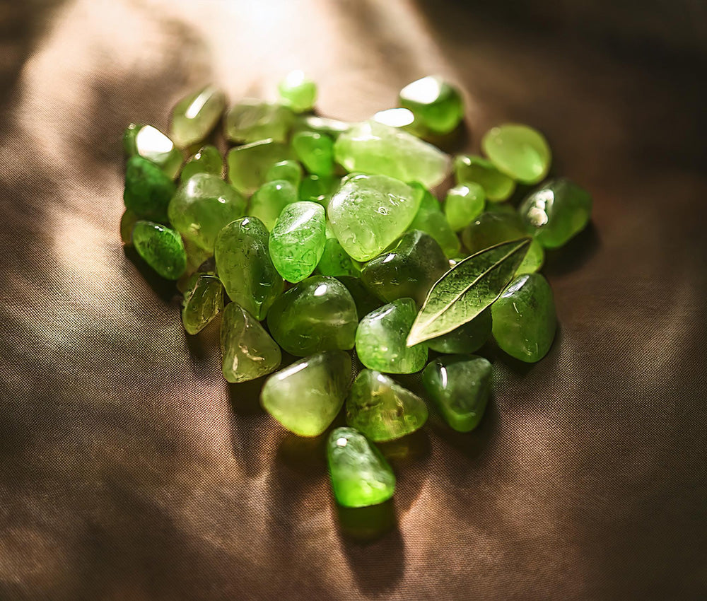 Peridot stones on a neutral background, highlighting their connection to the Heart and Solar Plexus Chakras for love and confidence.