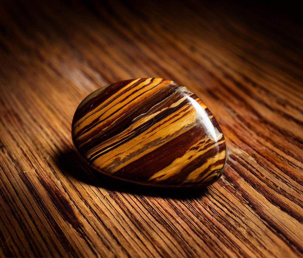 Tiger’s eye stones on a warm surface, symbolizing power, protection, and their historical significance in ancient cultures.