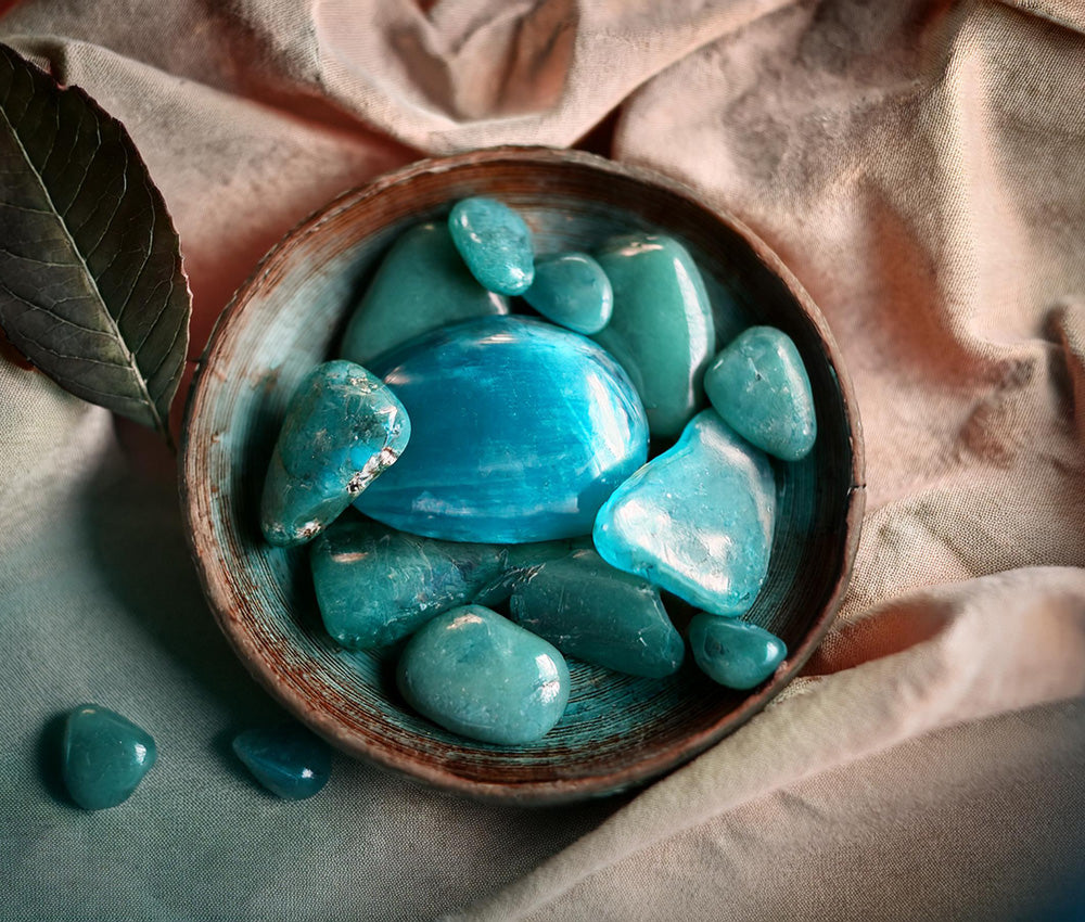 Turquoise stones on a neutral surface, highlighting their connection to the Throat and Heart Chakras for communication and emotional healing.