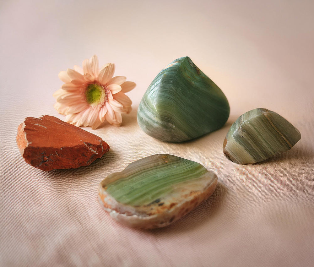 Unakite stones on a neutral background, highlighting their connection to the Heart and Third Eye Chakras for emotional healing and spiritual insight.